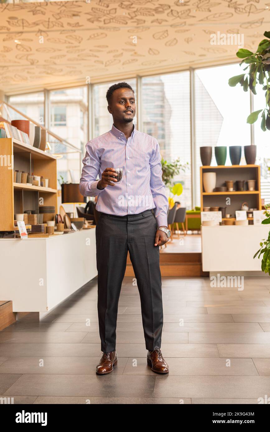Portrait complet de l'homme d'affaires africain à l'intérieur du café Banque D'Images