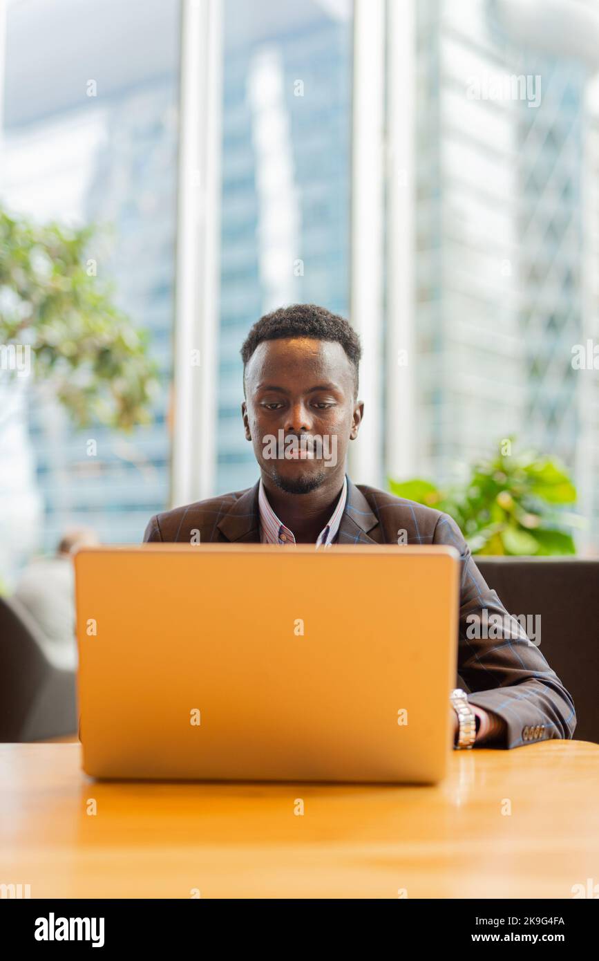 Homme d'affaires africain utilisant un ordinateur portable au café Banque D'Images