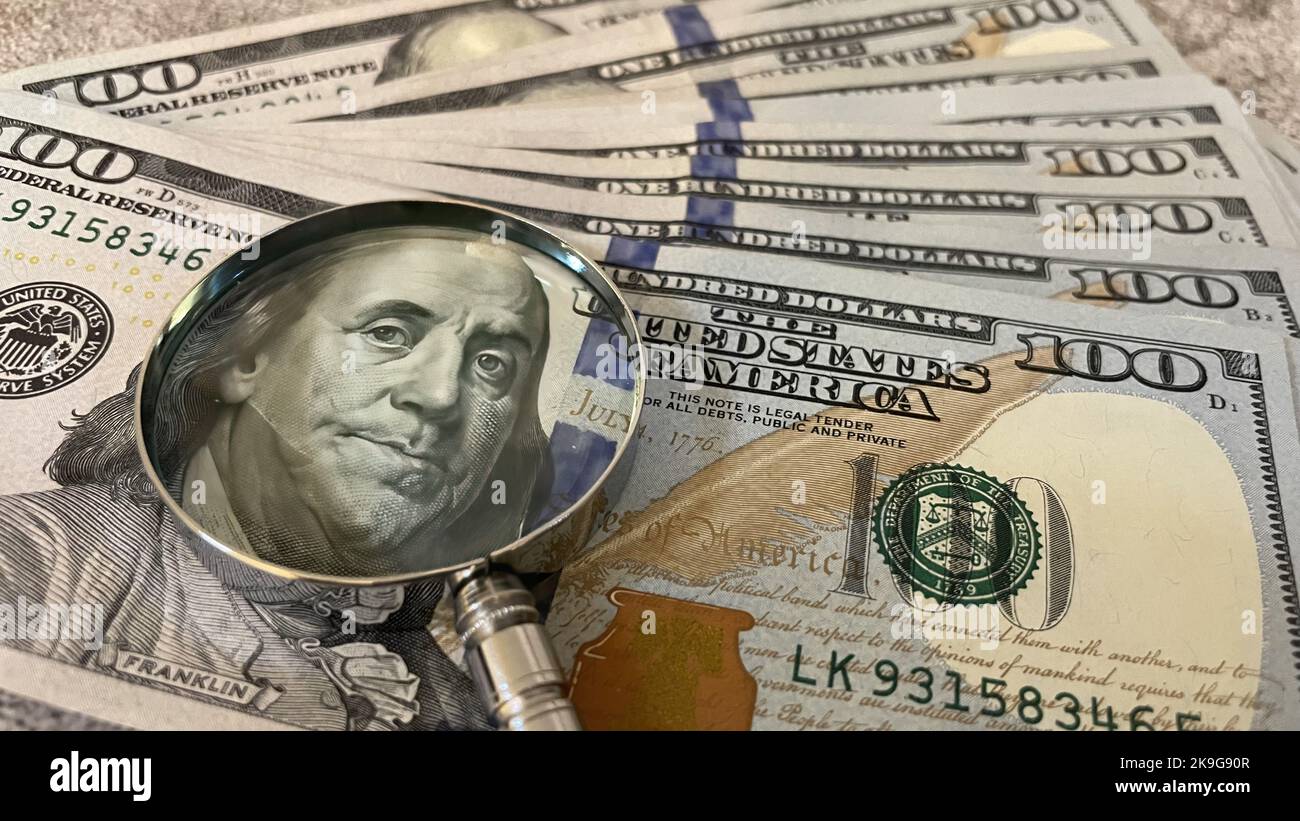 Un gros plan d'une pile de billets en dollars américains sous une loupe Banque D'Images