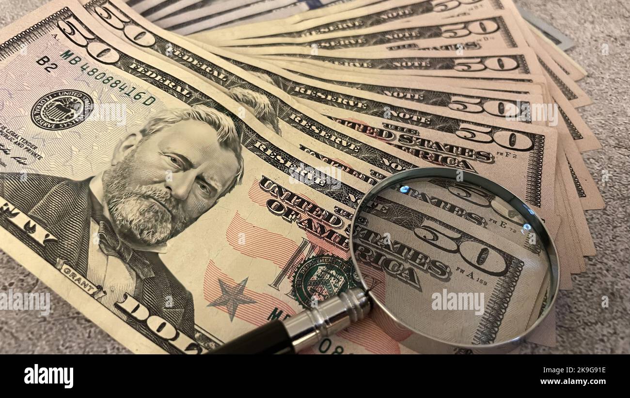 Gros plan d'une pile de billets en dollars américains sous une loupe Banque D'Images