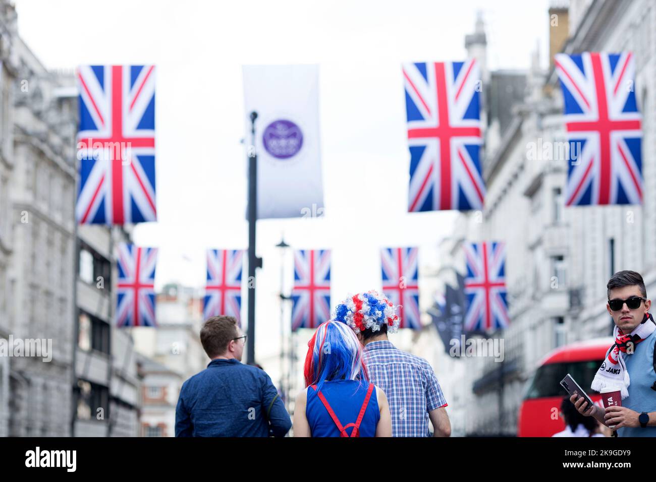 Les fêtards des costumes sur le thème de Union Jack regardent dans Piccadilly Circus, dans le centre de Londres, le premier jour du week-end du Jubilé de platine. Banque D'Images