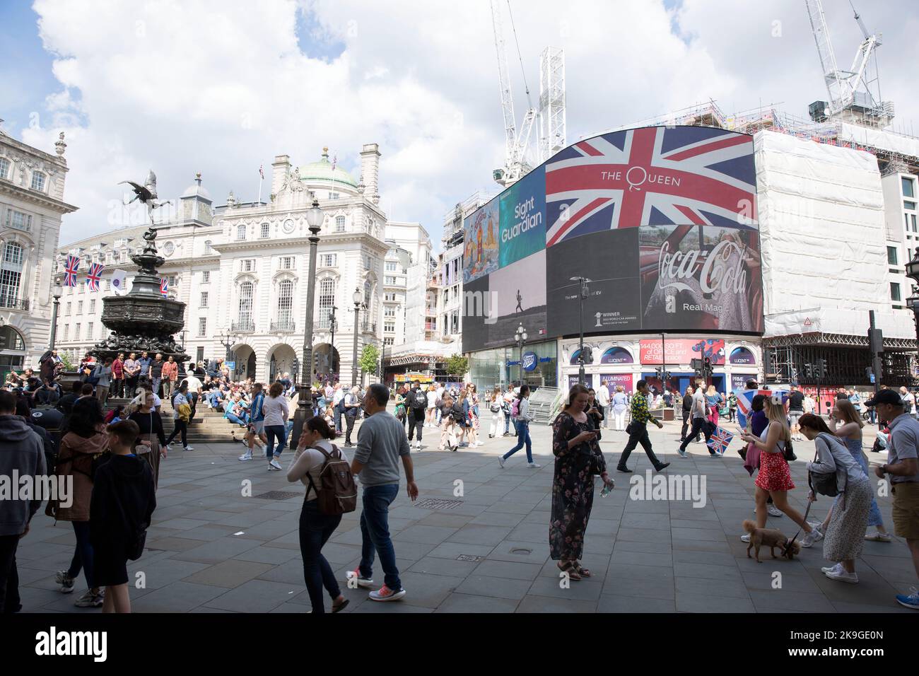 Les gens marchent devant un drapeau de l'Union avec un logo sur un tableau électrique à Piccadilly Circus, Londres, le premier jour du week-end du jubilé de platine. Banque D'Images