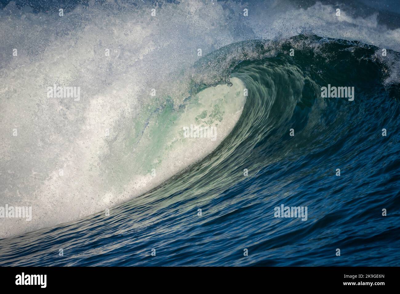 La vague bleue de l'océan Atlantique se brise, la pulvérisation vole sur la rive d'Hermanus. Whale Coast, Overberg, Western Cape, Afrique du Sud. Banque D'Images