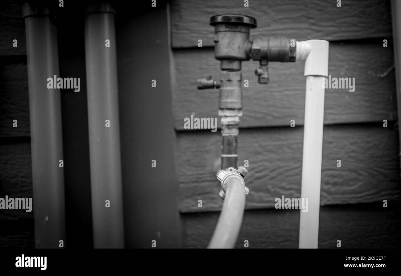 Hivernage d'un système d'irrigation résidentiel à l'aide d'un compresseur et d'air forcé pour souffler les conduites vides. Banque D'Images