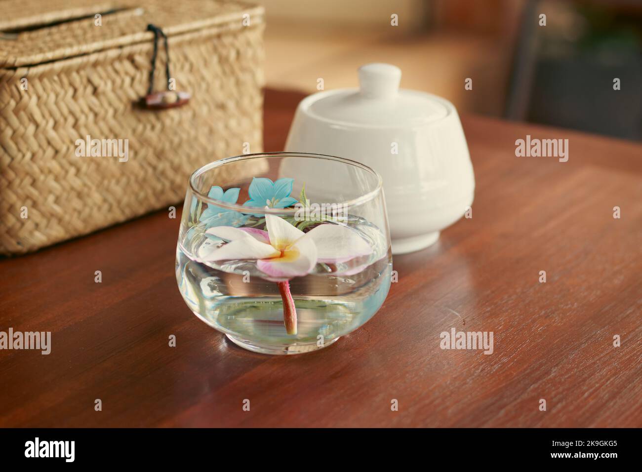 Une fleur de frangipani dans un verre d'eau comme table centrale montrant un espace de vie relaxant, bien-être et bien-être Banque D'Images