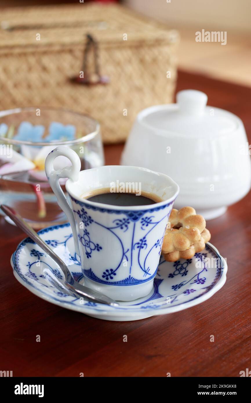 Une dose d'espresso dans une demitasse en céramique élégante accompagnée d'un biscuit sucré dans un café Banque D'Images