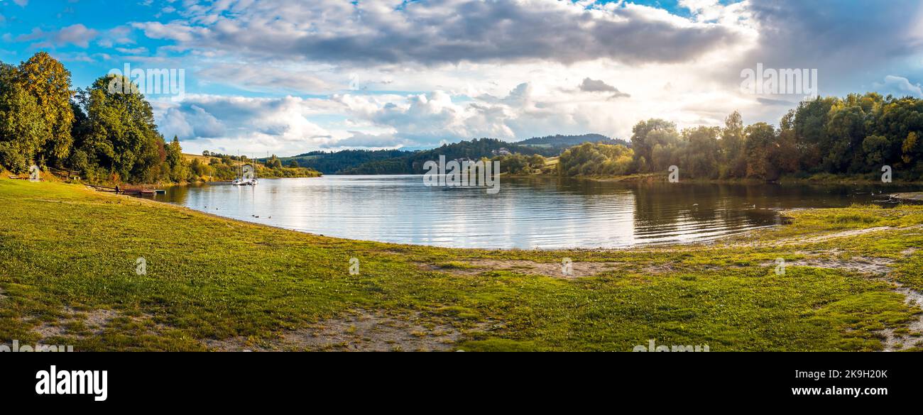 Baie sur le lac Czorsztyn. voiliers amarrés dans une petite marina. Une plage herbeuse avec le soleil couchant. Czorsztyn, Pologne Banque D'Images