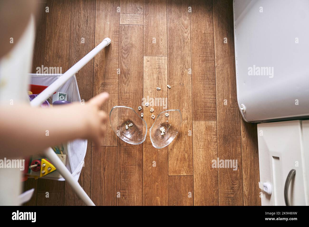 Un petit bébé sur une chaise haute a déposé une tasse de soupe de nouilles sur le parquet. La plaque transparente est divisée en deux parties. Nouilles sous forme de chiffres. La table est sale. Photo de haute qualité Banque D'Images Un petit bébé sur une chaise haute a déposé une tasse de soupe de nouilles sur le parquet. La plaque transparente est divisée en deux parties. Nouilles sous forme de chiffres. La table est sale. Photo de haute qualité Banque D'Images