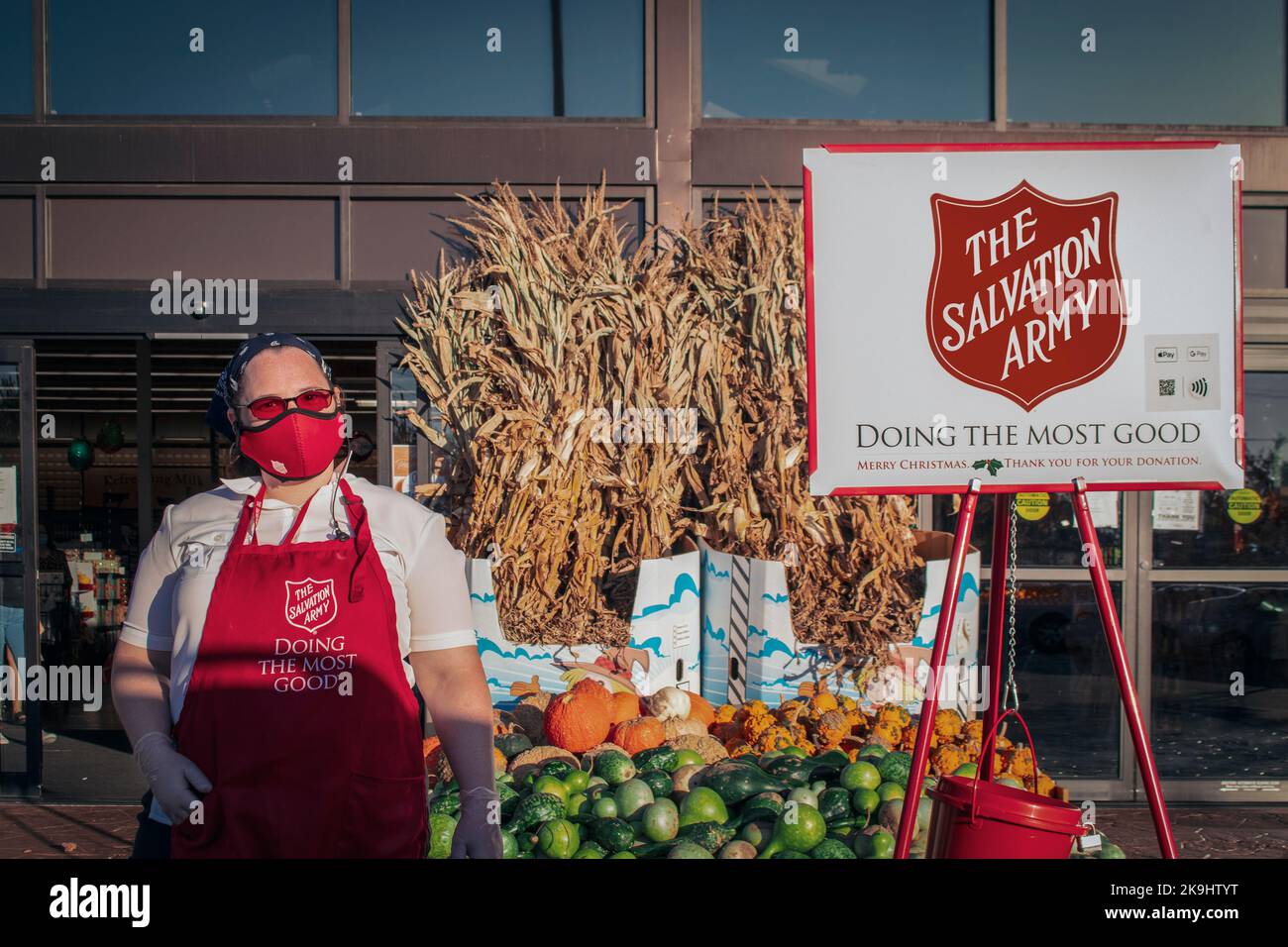 2020 11 07  Tulsa USA une femme masquée collectant de l'argent pour l'Armée du Salut par pile de citrouilles et de gourdes et de paille ornementale avec signe et bu Banque D'Images