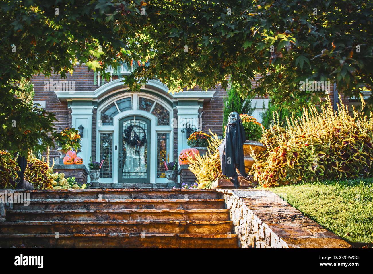 Décorations d'Halloween entourant les marches et entrée à la maison dans un magnifique propriété paysagée Banque D'Images