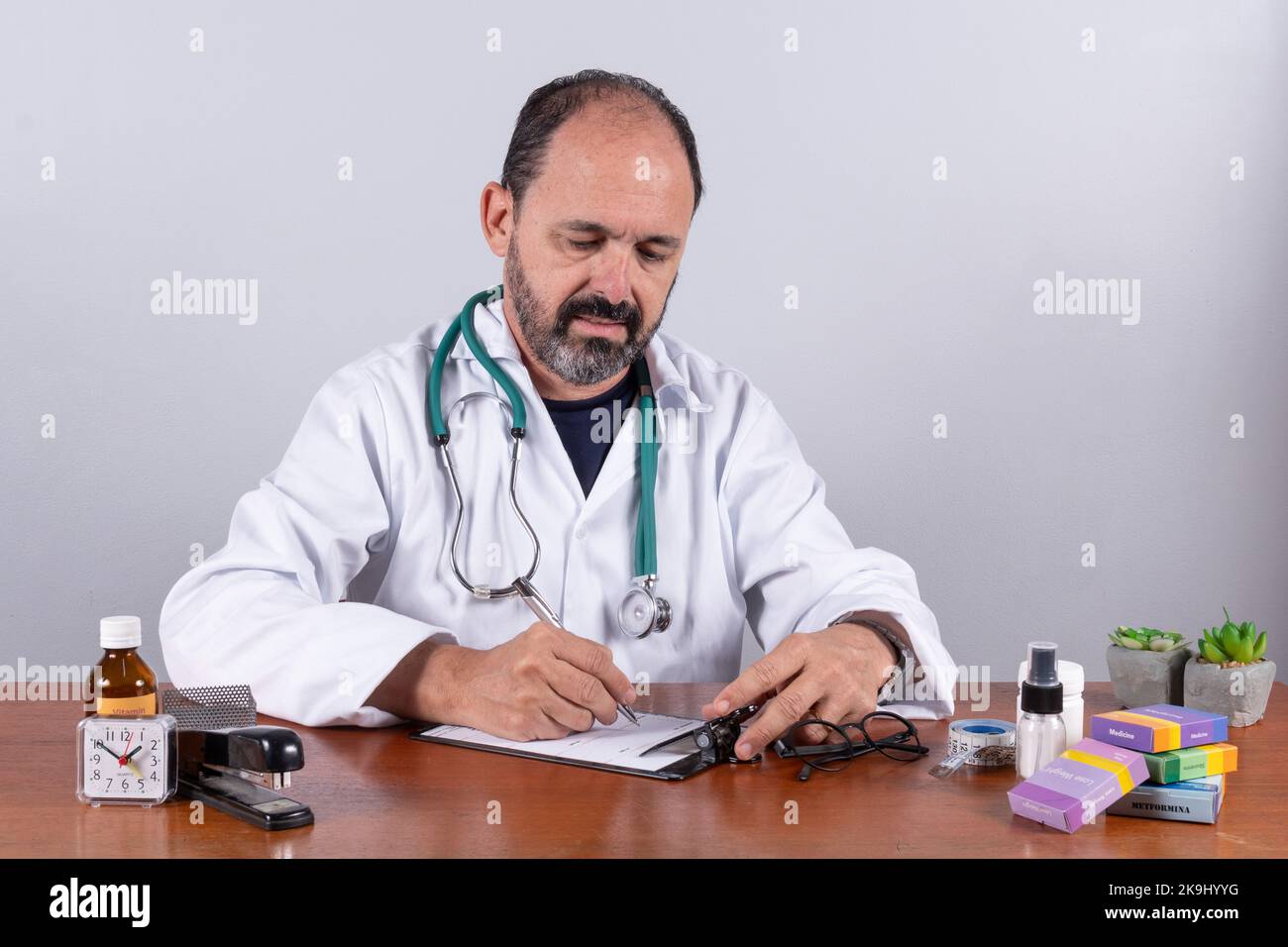 Portrait d'un médecin mature senior écrivant sur ordonnance Banque D'Images