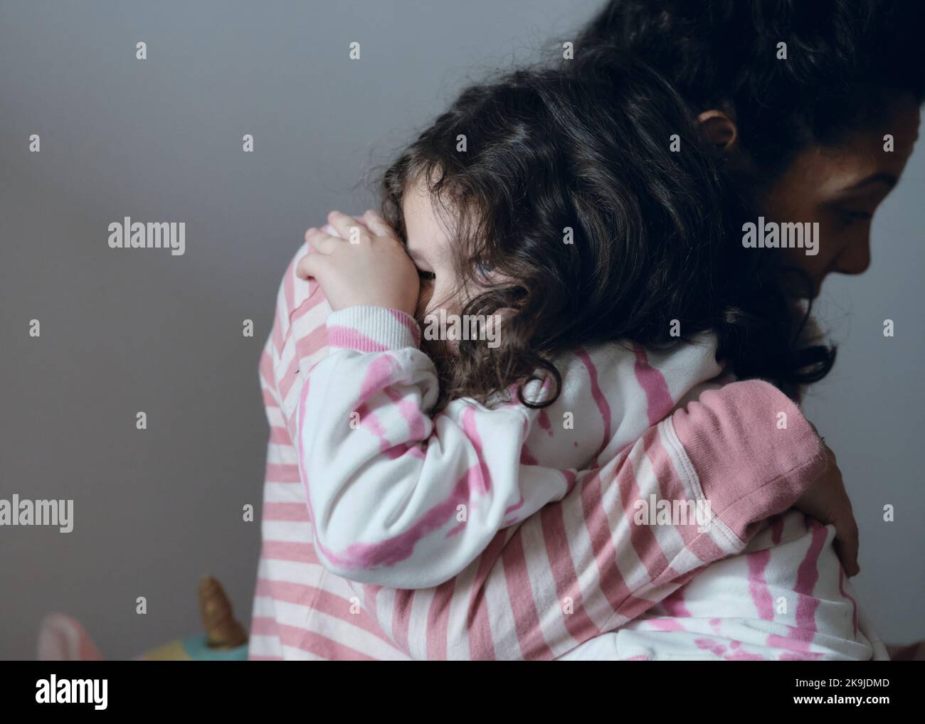 Une petite fille contrariée étant consolée par sa mère Banque D'Images