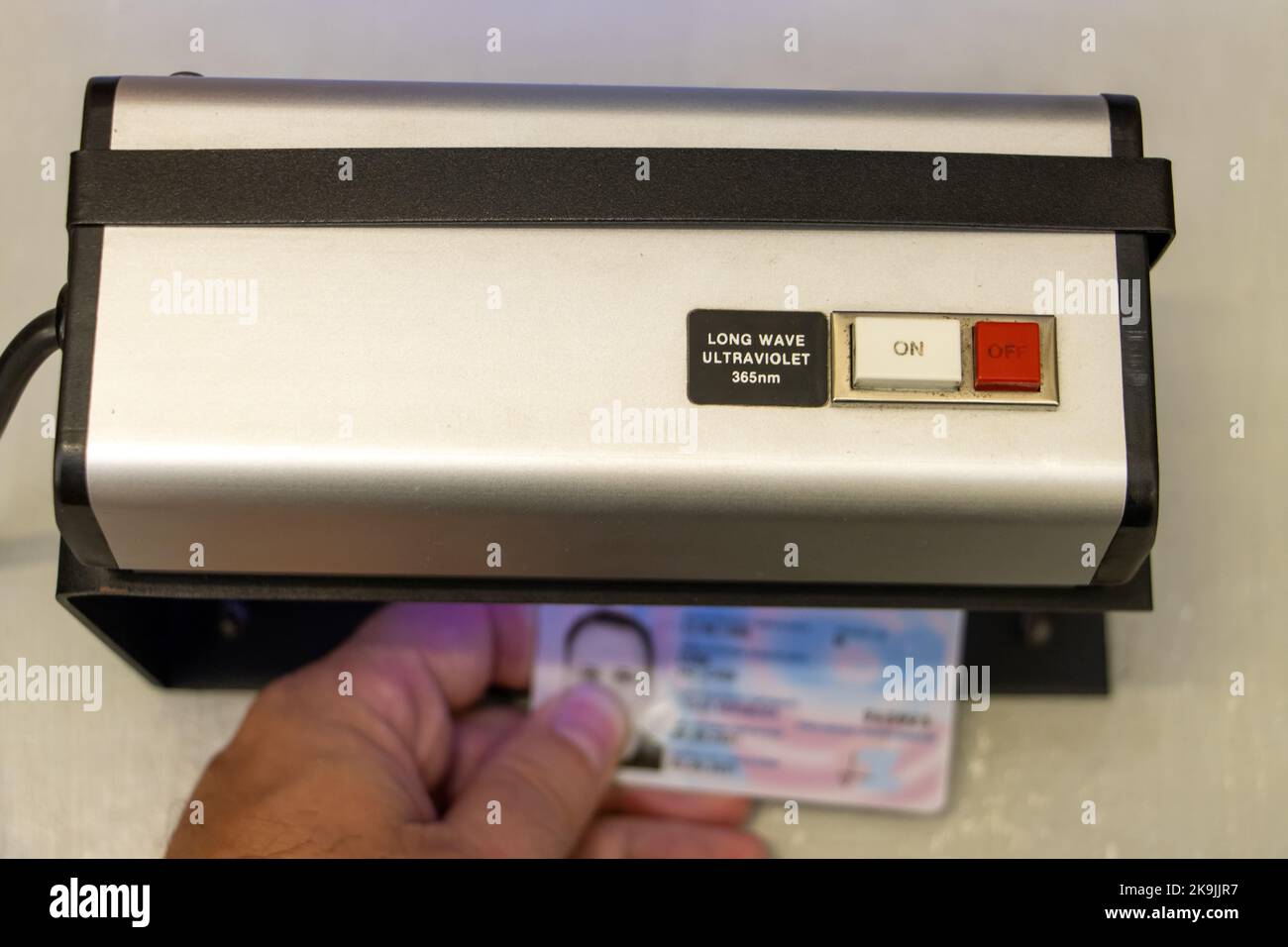 Vérification de la validité d'un document d'identification personnel sous lumière ultraviolette Banque D'Images