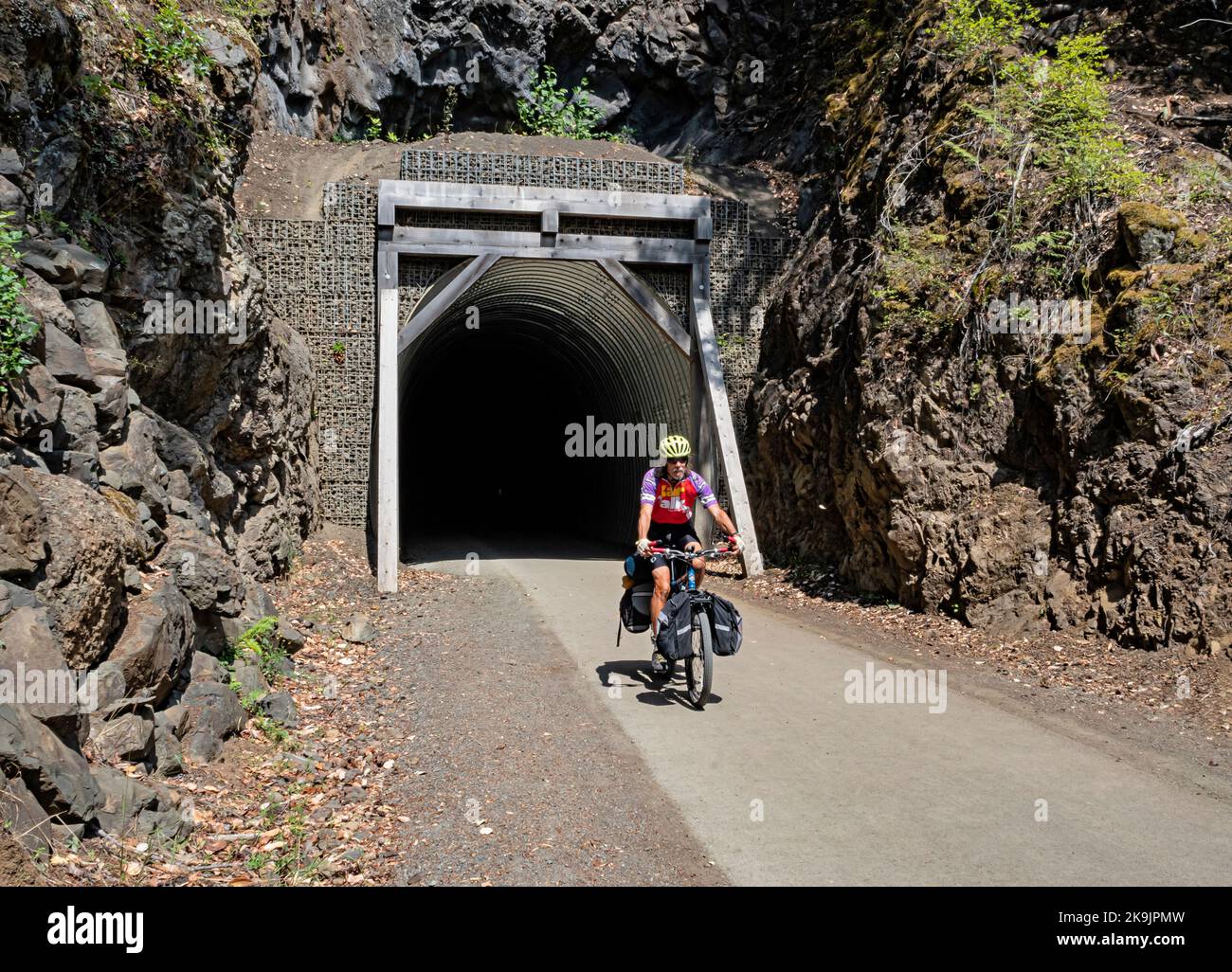 WA22651-00...WASHINGTON - cycliste sortant du tunnel McPhee sur le sentier de découverte olympique le long des rives du lac Crescent dans le parc national olympique. Banque D'Images