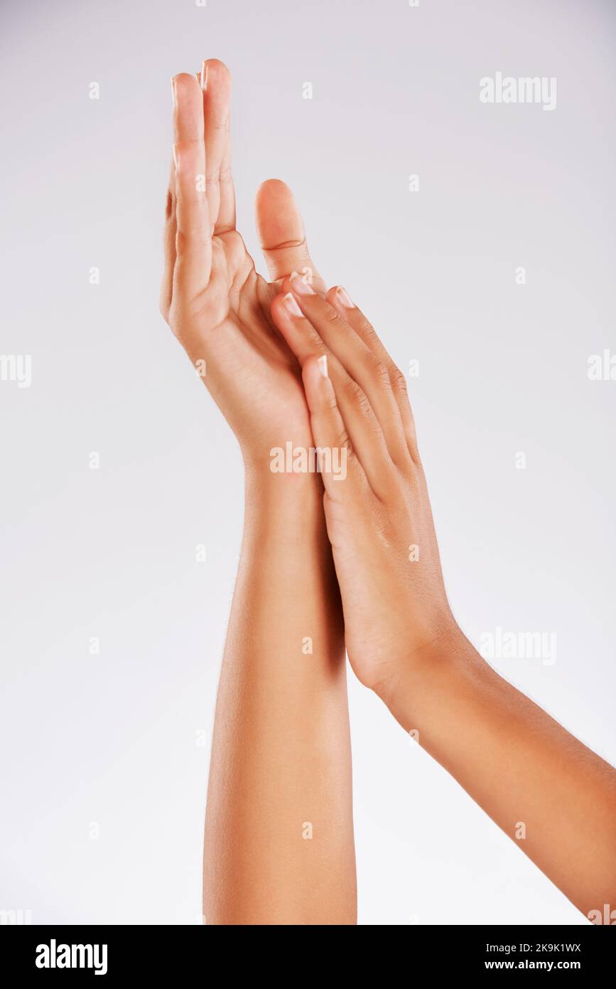 Doux au toucher. Photo en studio d'une main de jeune femme méconnaissable sur fond gris. Banque D'Images