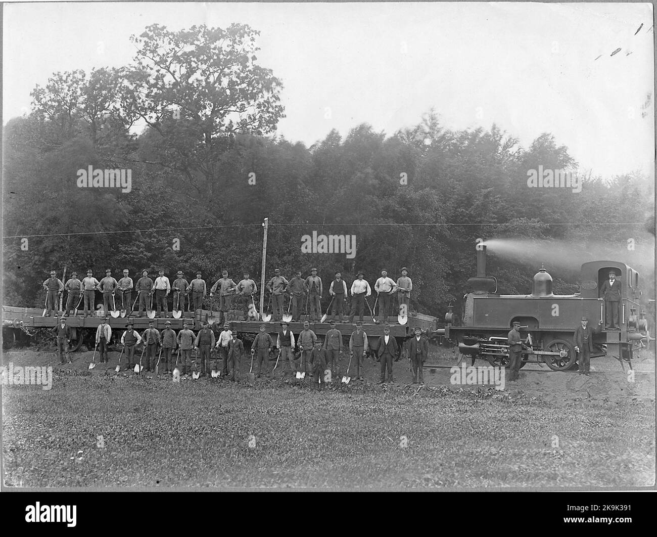 Équipe de travail aux trains de gravier sur la ligne entre Markaryd et Värnamo. La locomotive à vapeur a été fabriquée par l'atelier mécanique d'Helsingborg en 1897 avec le numéro de fabrication 12 pour le moulin à sucre de Hälsingborgs. Banque D'Images