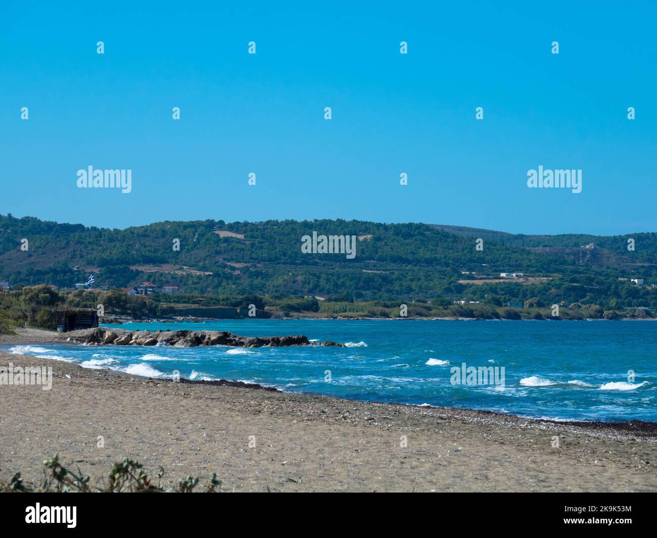 Belle plage déserte sur la côte ouest de Rhodes près de Kamiros. Eau de mer turquoise, ciel bleu sans nuages, plage de galets. Banque D'Images