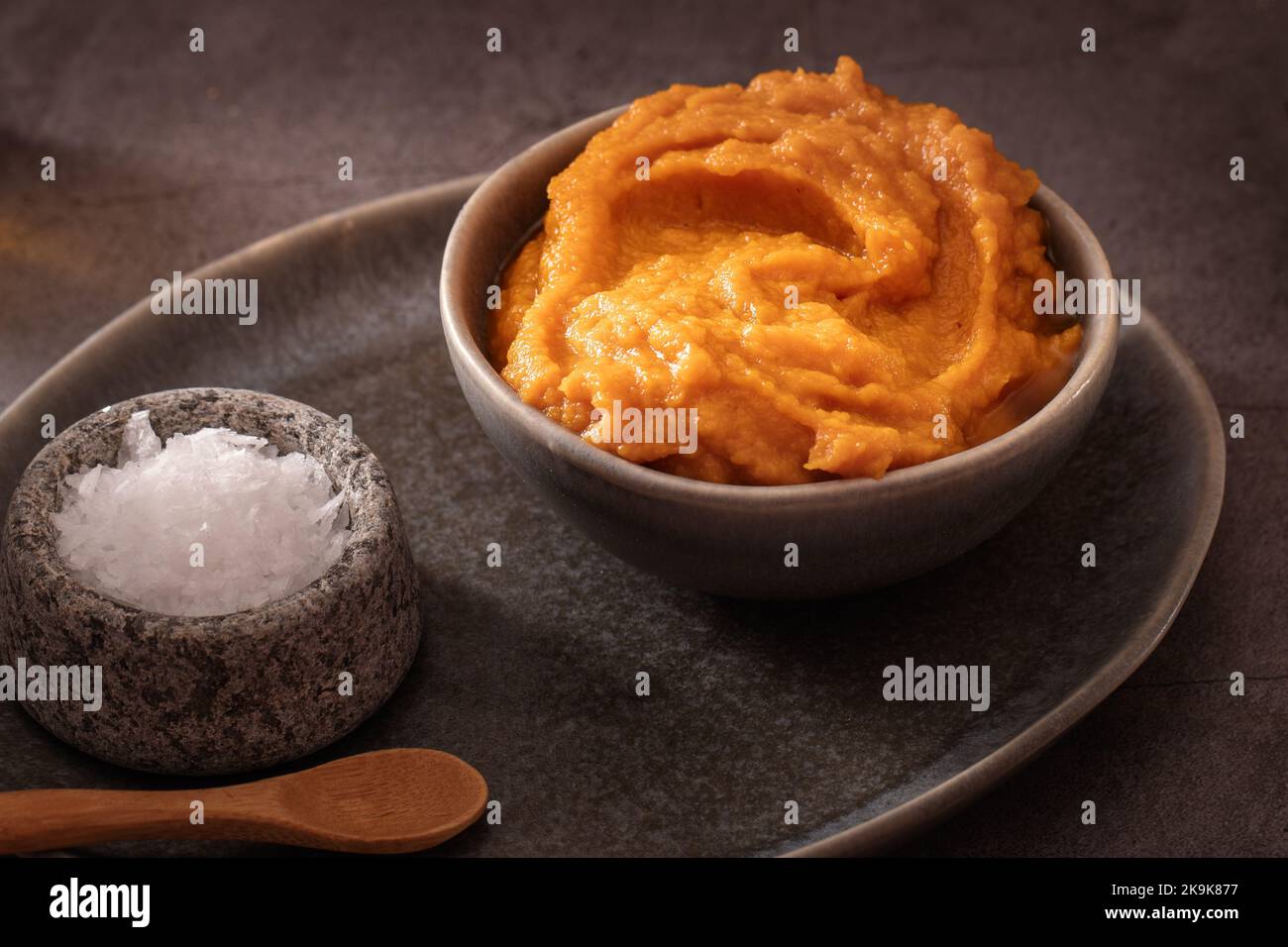 Purée de citrouille maison pour cuisiner sur fond sombre et sombre Banque D'Images