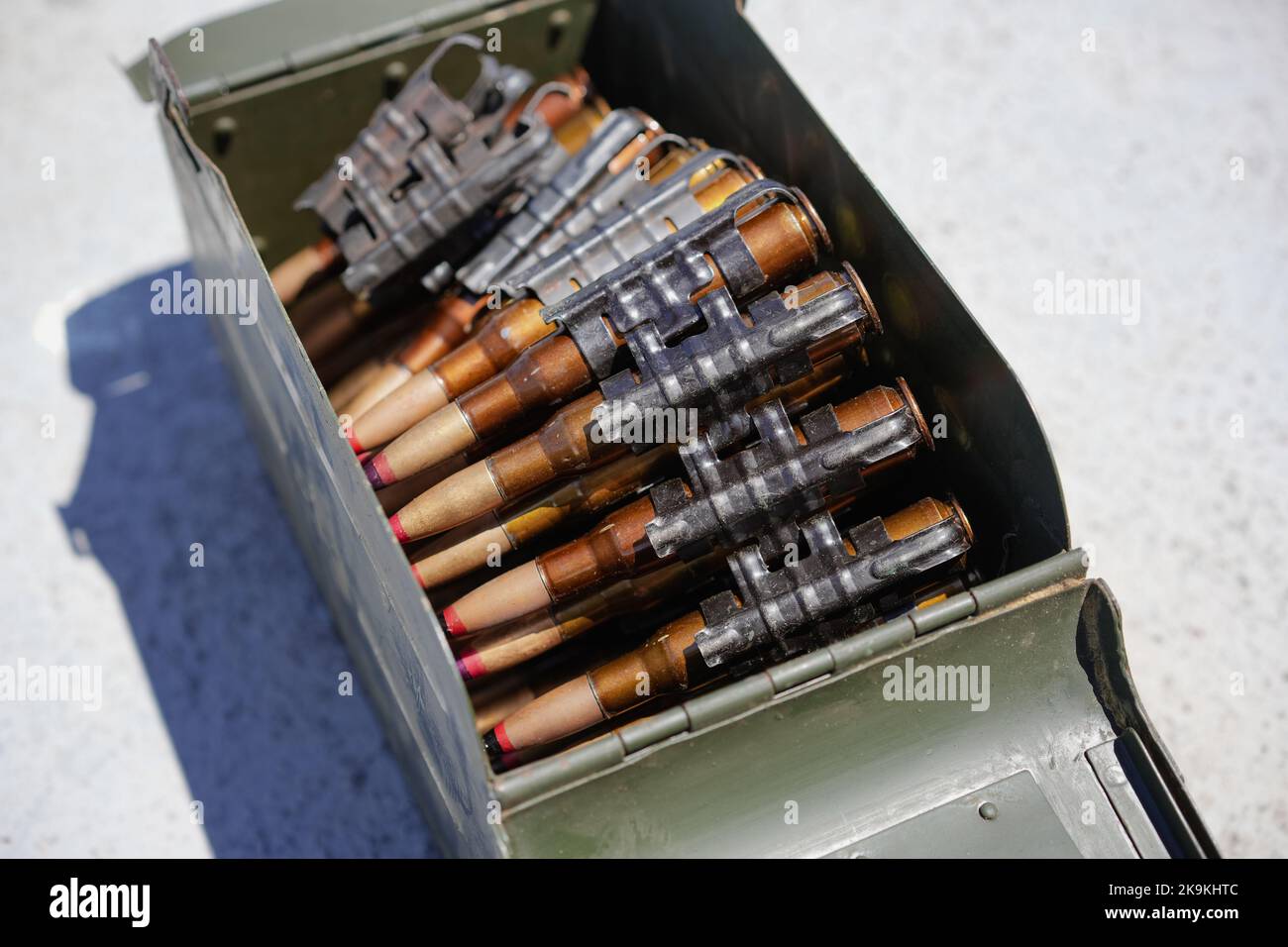 Gros plan d'une courroie de mitrailleuse chargée de cartouches, dans une boîte de munitions. Banque D'Images