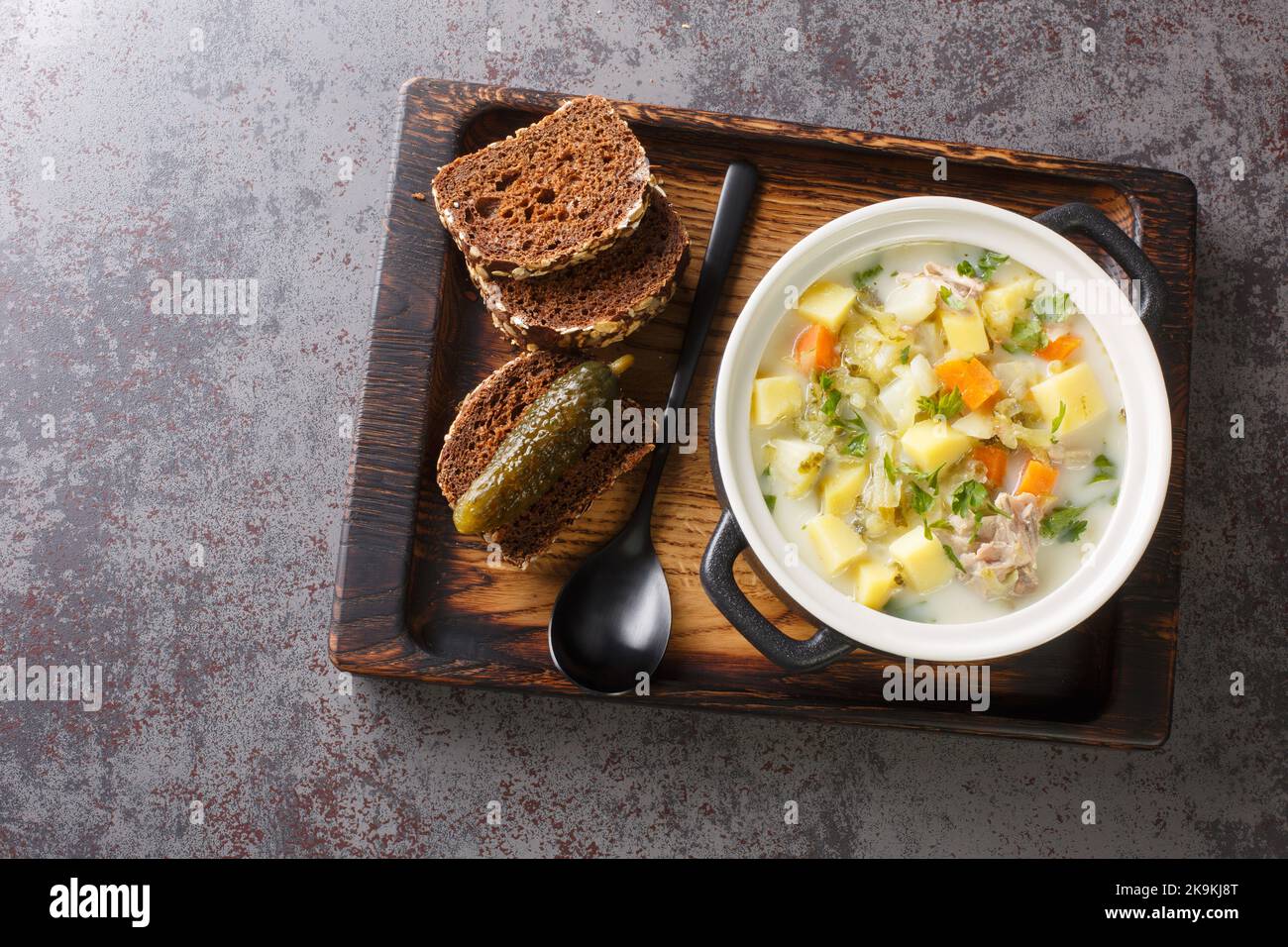 Ogorkowa Zupa crémeux polissé de pickle de Dill polonais avec légumes-racines sur la casserole sur le plateau en bois vue horizontale du dessus Banque D'Images
