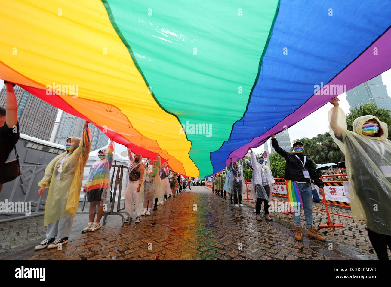 Taipei, Taïwan. 29th octobre 2022. Participants au drapeau arc-en-ciel géant de la parade de la fierté LGBT de Taipei, Taipei, Taïwan. Le 20th anniversaire de la parade a eu lieu malgré la pluie et les participants ont bravé les éléments la plupart du temps avec des parasols mais cela n'a pas affecté l'humeur ou le plaisir. Des dizaines de milliers de personnes se sont jointes à la parade qui a eu lieu sur un itinéraire en circuit depuis l'hôtel de ville de Taipei, à l'ombre du plus haut bâtiment de Taïwan, Taipei 101. Taiwan est le pays le plus progressiste de tous les pays asiatiques en matière de droits LGBT et a été le premier pays asiatique à reconnaître légalement le mariage entre conjoints de même sexe. CRE Banque D'Images
