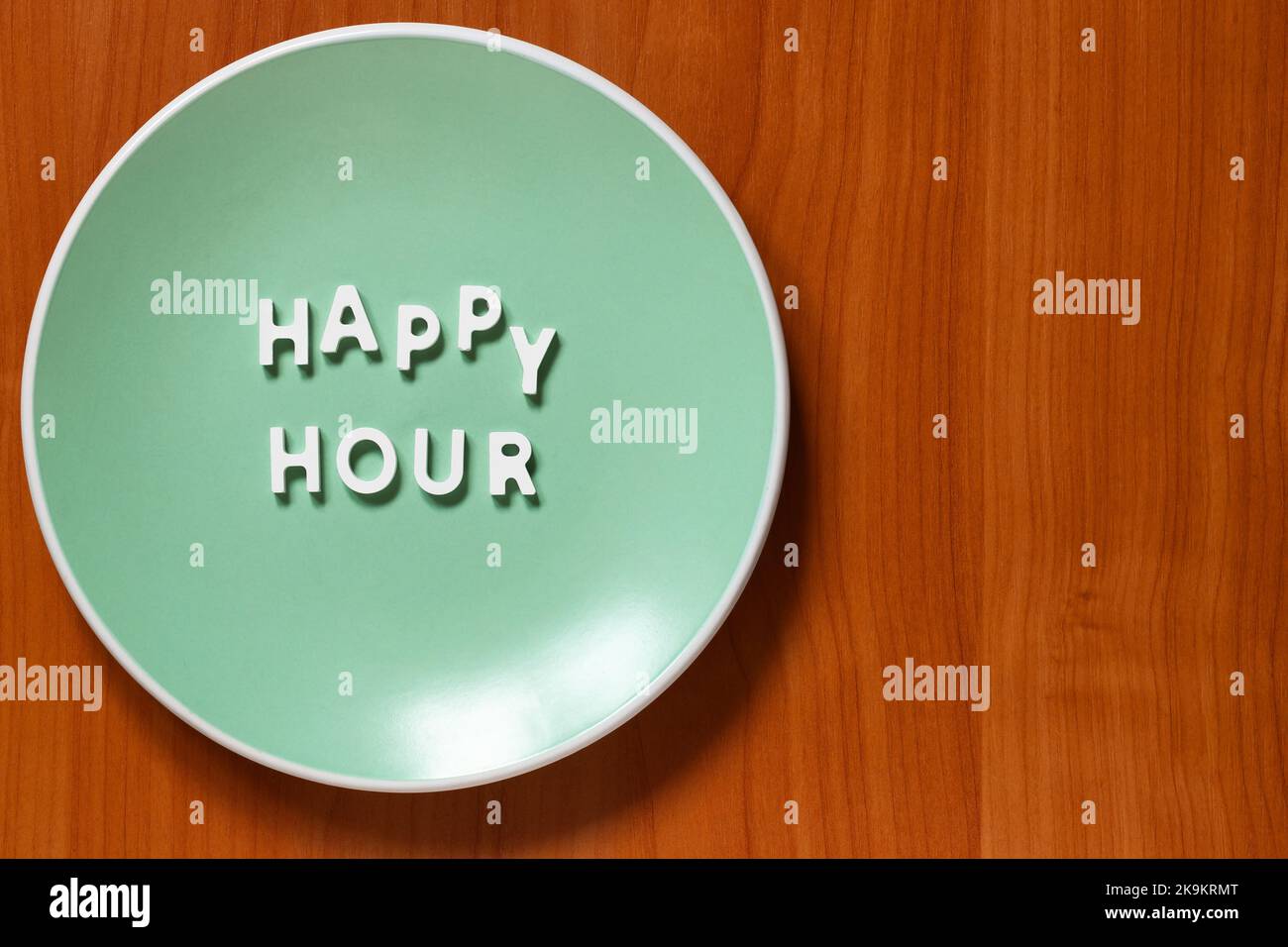 Happy Hour - assiette avec texte sur table en bois et espace pour votre propre texte Banque D'Images