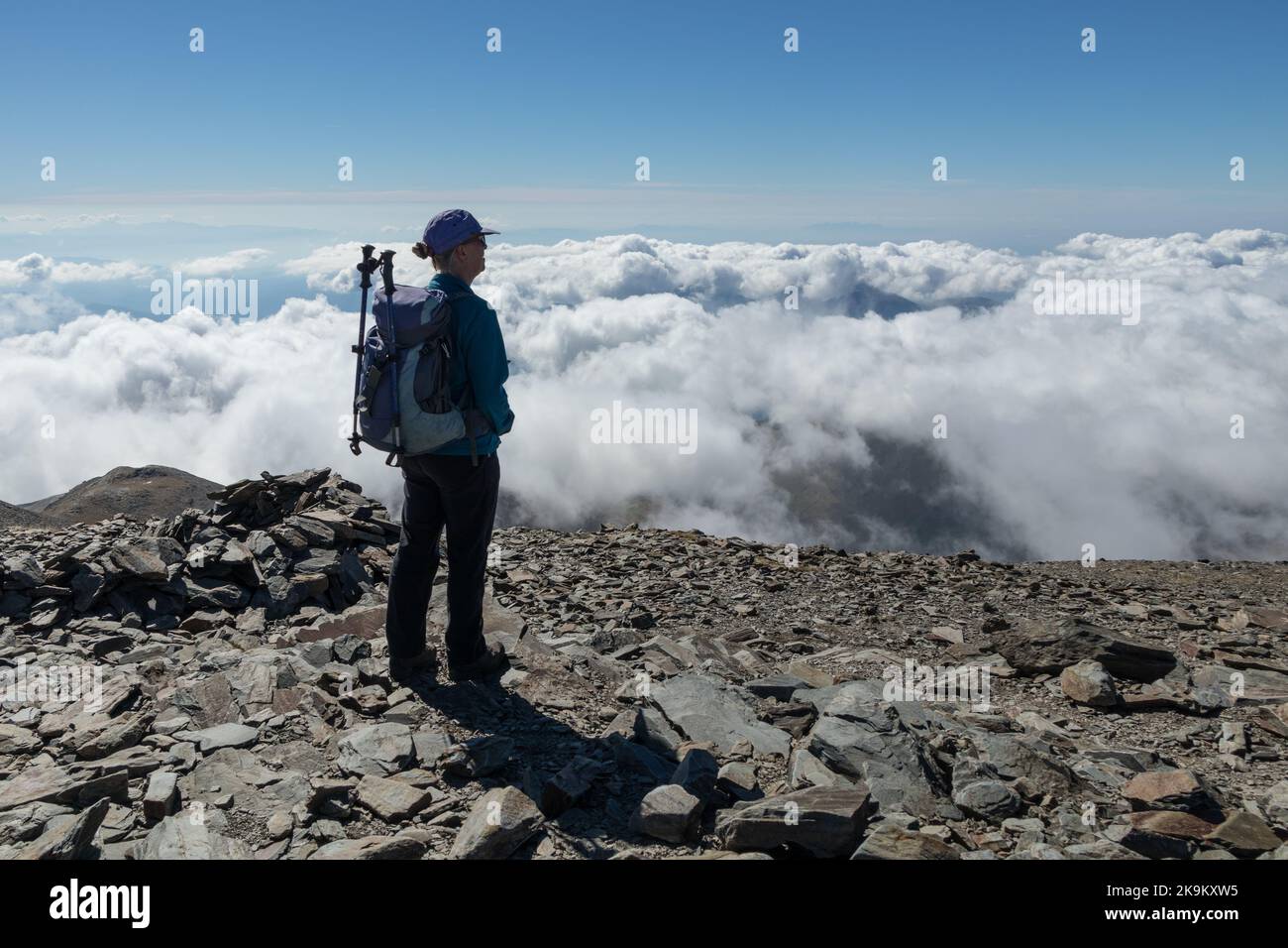 Walker dans ses années 60 appréciant la vue au-dessus des nuages sur le sommet du Puigmal, catalan, Pyrénées, Espagne Banque D'Images
