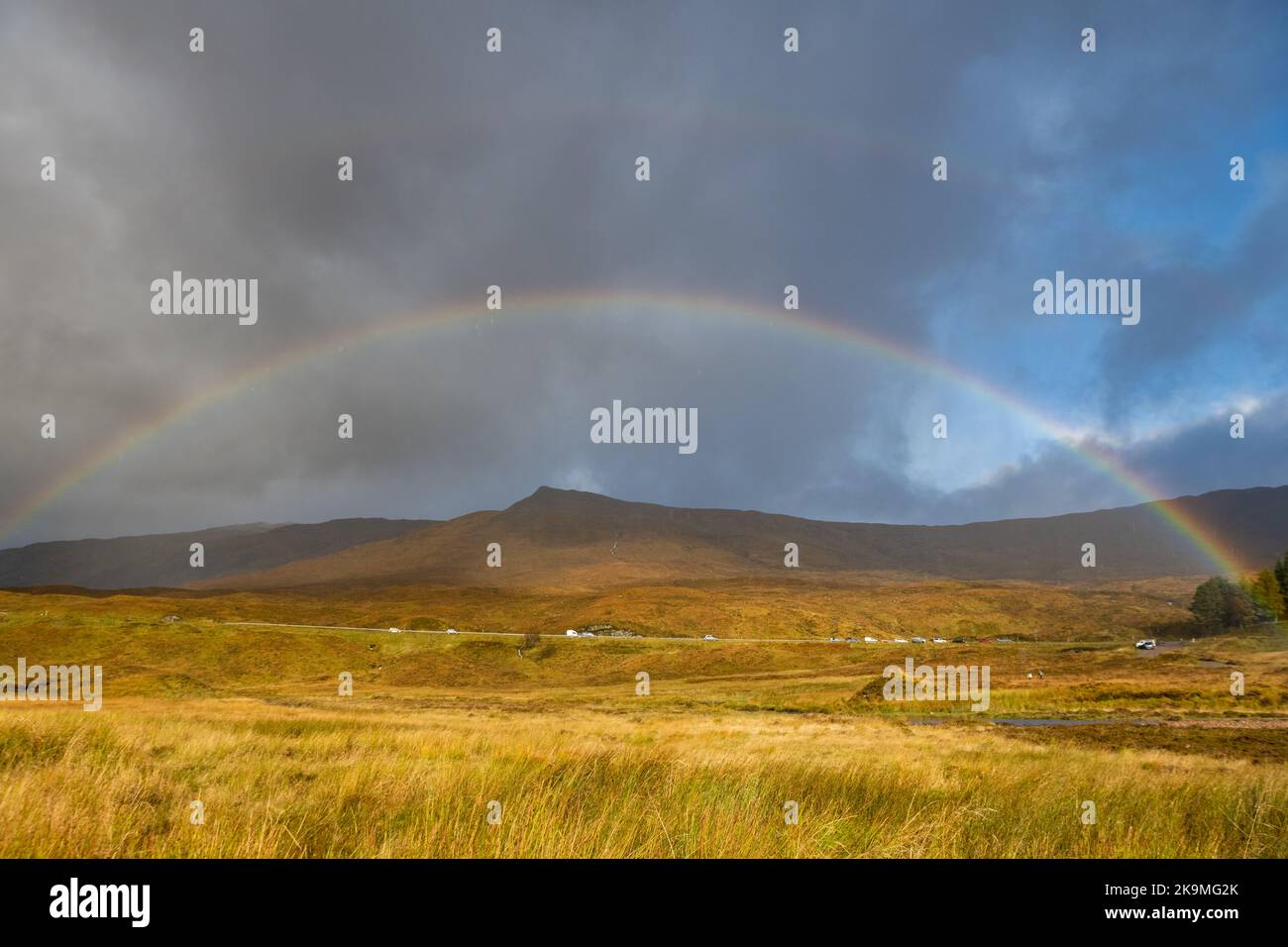 Rainbow au-dessus de la circulation sur la route A82 à travers Glen COE, Écosse, Royaume-Uni Banque D'Images