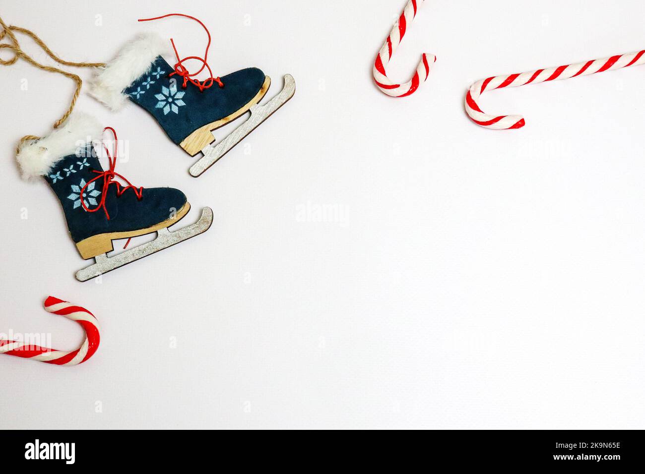 Arrière-plan pour Noël. sucettes de noël et patins à jouets pour arbre de Noël sur fond blanc. Décorations de Noël et nouvel an. Banque D'Images