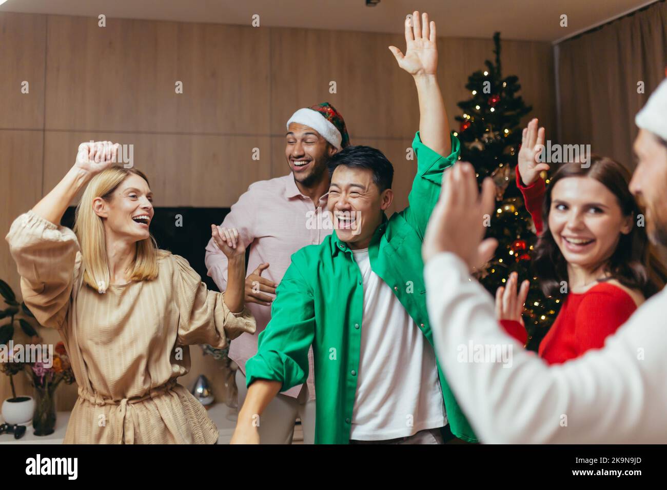 Joyeux groupe amis fêtent la fête du nouvel an à la maison dansant ensemble la veille de Noël s'amuser. Maison fête du nouvel an. Passer du temps ensemble vacances humeur drôle homme et femme. Banque D'Images