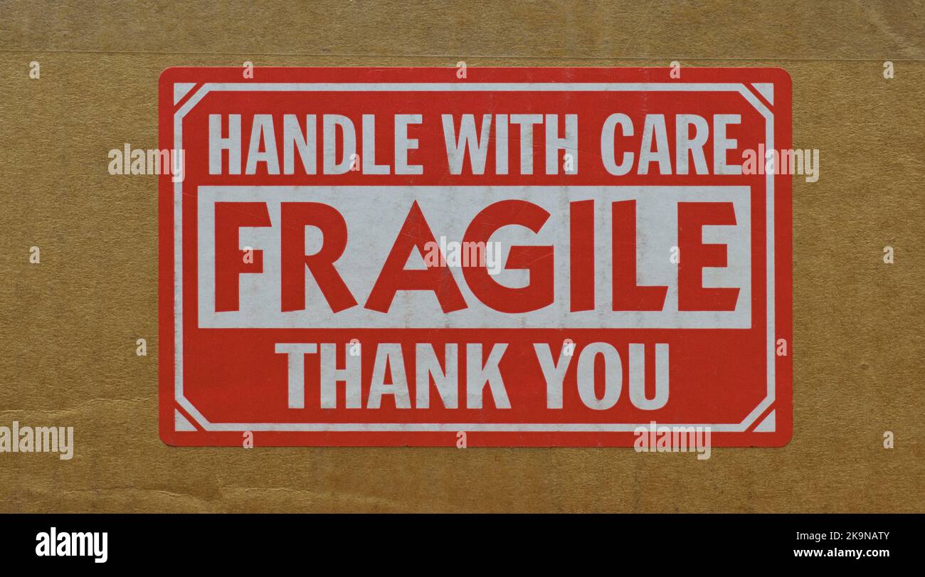 Manipuler avec un autocollant d'entretien fixé sur le côté d'une boîte en carton. Gros plan vue avant isolée et image centrée. Banque D'Images