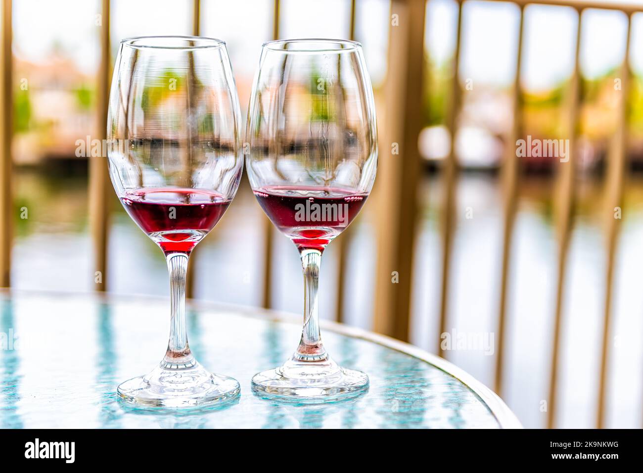 Deux verres de vin rouge français coulé Cotes du Rhone sur un balcon en verre à Miami, Floride avec vue Banque D'Images