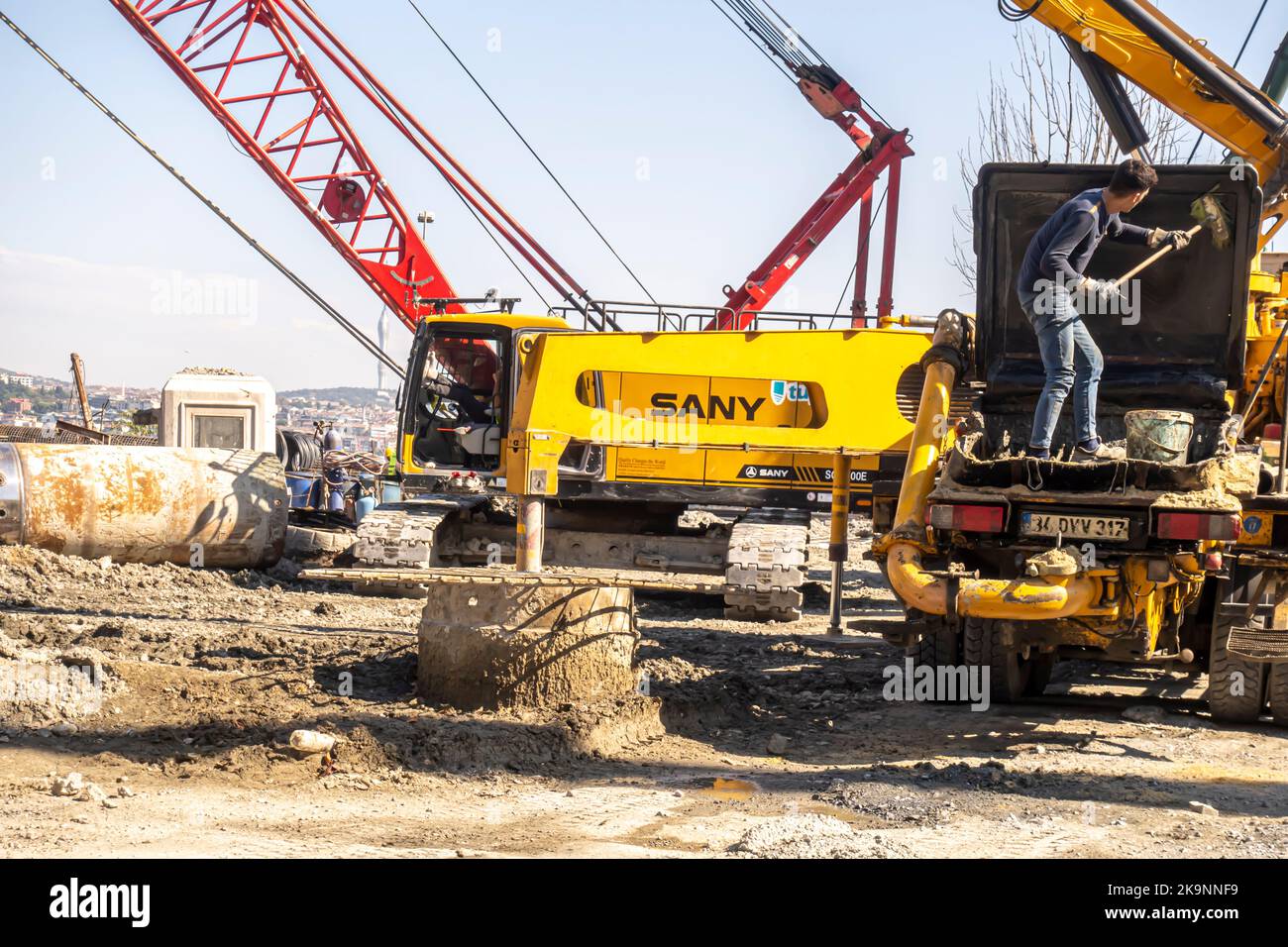 MACHINES pour béton COULÉ. Travailleur avec une pelle travaillant dans un camion à pompe en béton avec des travailleurs à Kadikoy, Istanbul, Turquie Banque D'Images