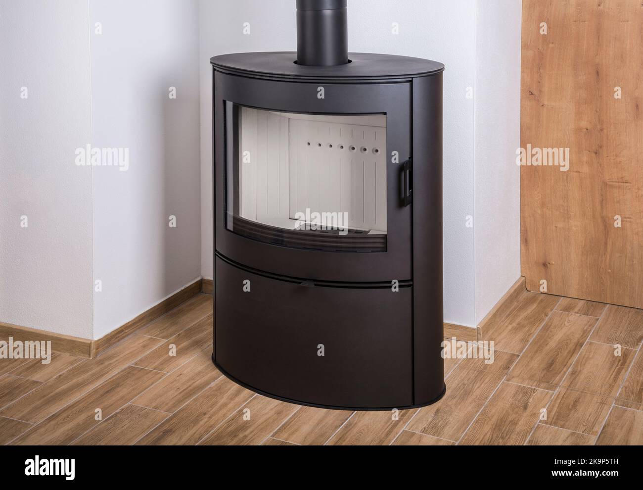 Nouveau poêle à bois en fer noir sur un sol en céramique Banque D'Images