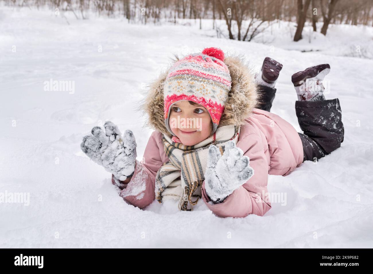 Jolie petite fille se trouve dans une chasse-neige en plein air en hiver Banque D'Images