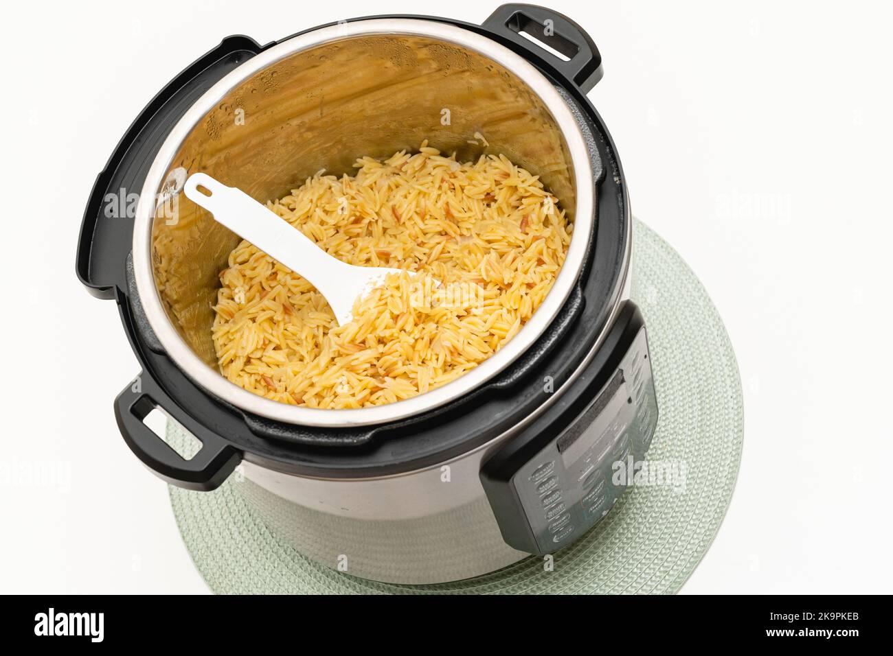 Pâtes cuites dans un pot instantané. Délicieux orzo pâtes gros plan dans un pot sur fond blanc avec espace de copie Banque D'Images