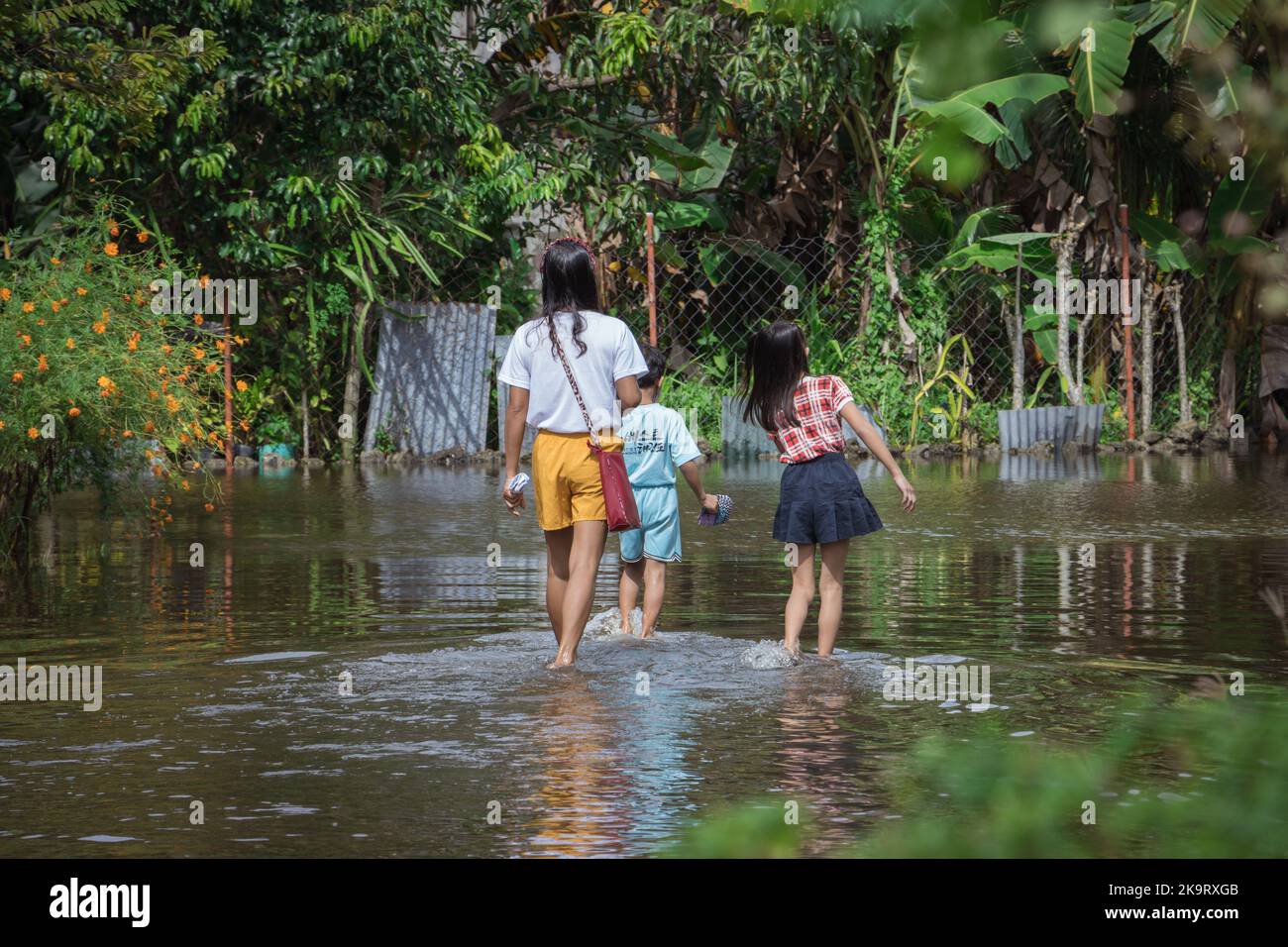 La tempête tropicale grave Paeng ou Nalgae a apporté des inondations et des pluies torrentielles au pays. Regardez les gens qui passent à gué dans la rue inondée. Banque D'Images