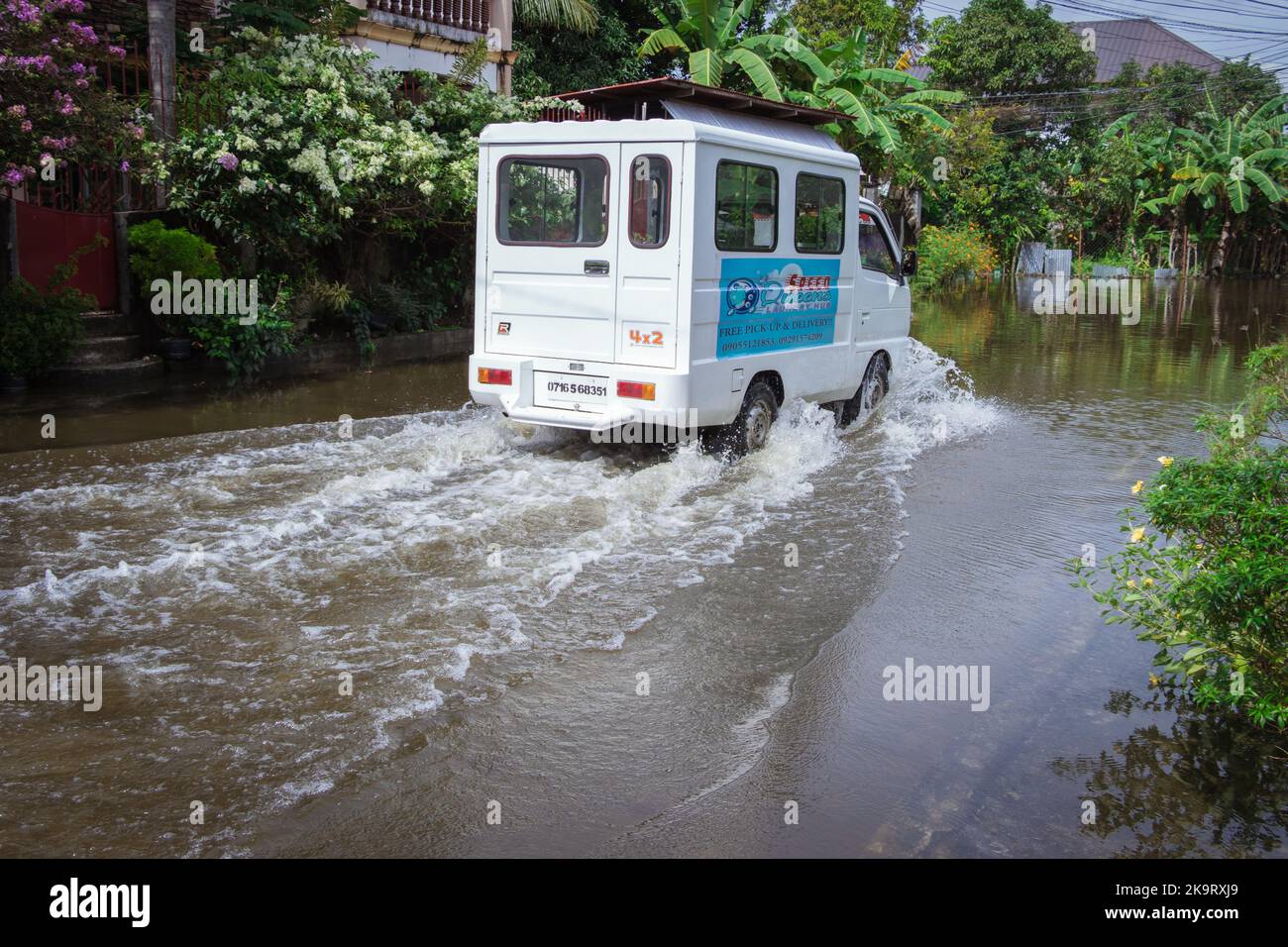 La tempête tropicale grave Paeng ou Nalgae a apporté des inondations et des pluies torrentielles au pays. Fourgonnette roulant sur une route inondée. Opération de décharge. Banque D'Images