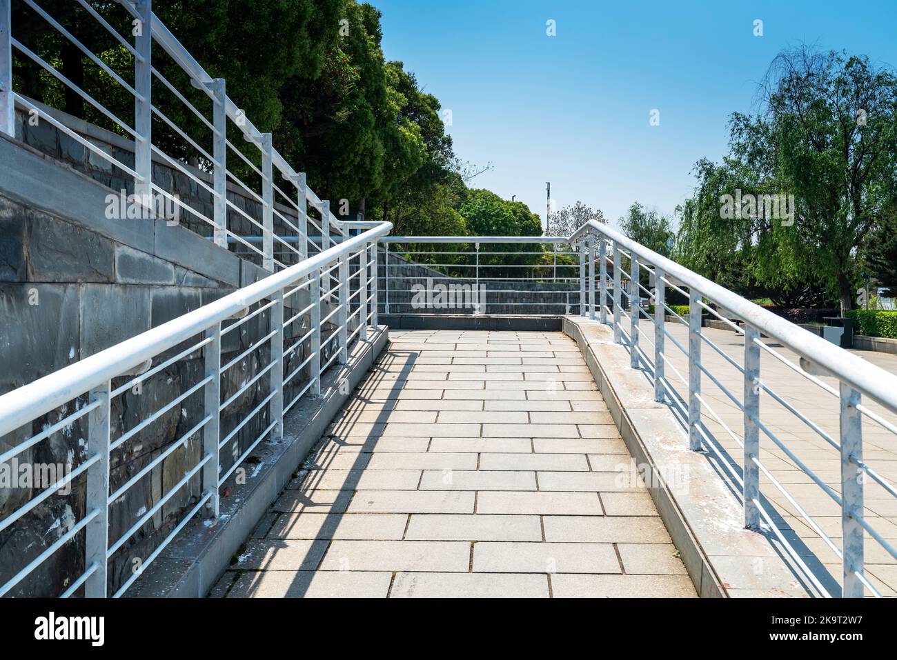 Une rampe pour fauteuil roulant, un avion incliné installé en plus ou à la place des escaliers, une passerelle pente pour personnes handicapées, personnes poussant des poussettes, des chariots Banque D'Images