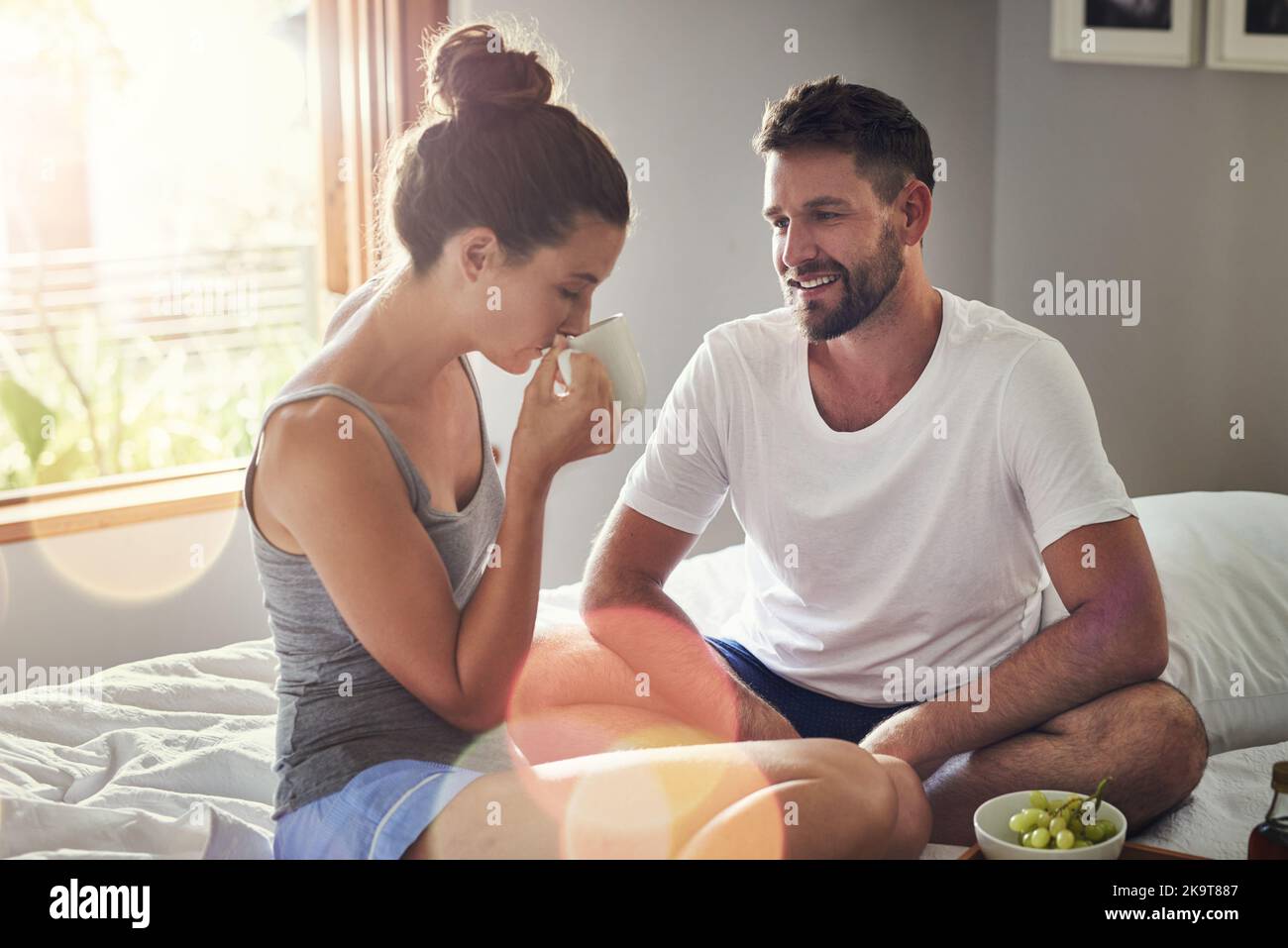 Vous ne savez pas à quel point vous me faites plaisir. Un jeune couple heureux prenant le petit déjeuner au lit ensemble à la maison. Banque D'Images