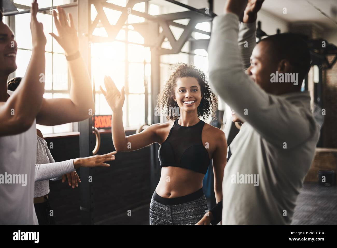 Tenez-vous aux personnes qui vous motivent à rester en forme. Un groupe de jeunes s'entraîner ensemble dans une salle de sport. Banque D'Images