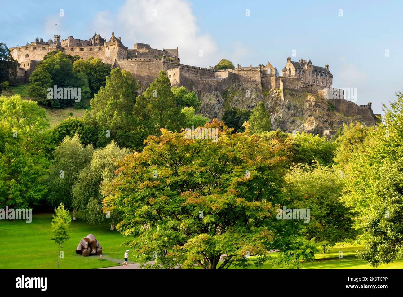17 septembre 2022 : Édimbourg, Écosse - Château d'Édimbourg, perché sur son rocher au-dessus des arbres sur Princes Street Gardens. Jogger passe. Banque D'Images