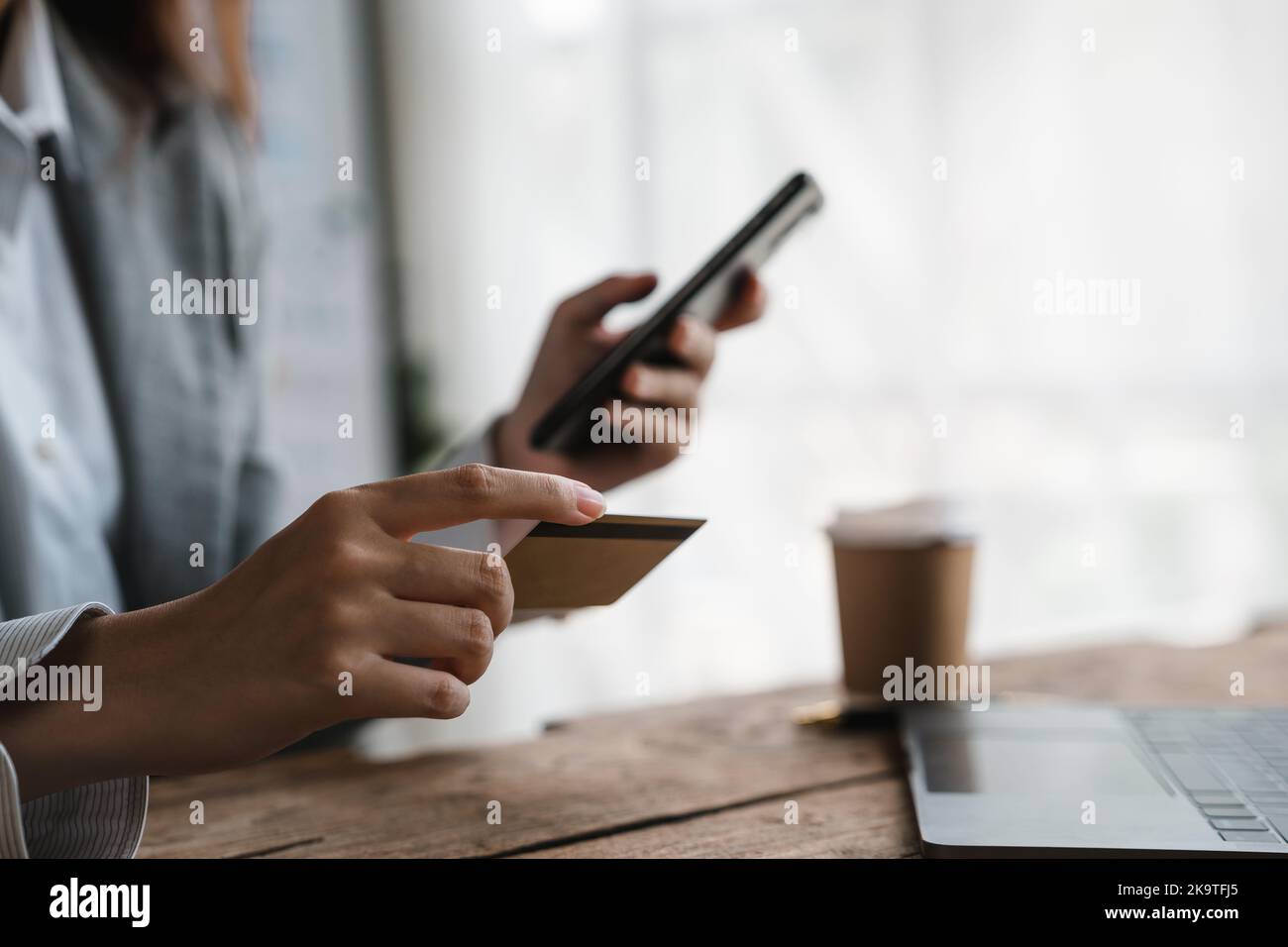 Femme en gros tenant un smartphone et une carte bancaire de crédit, impliquée dans le shopping mobile en ligne à la maison, femme achetant des biens ou des services sur Internet Banque D'Images