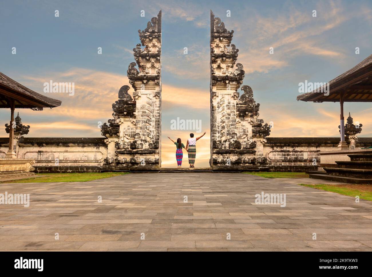 Couple asiatique debout dans les portes du temple tenant la main de l'autre. Coucher de soleil à Pura Lempuyang, Bali, Indonésie Banque D'Images