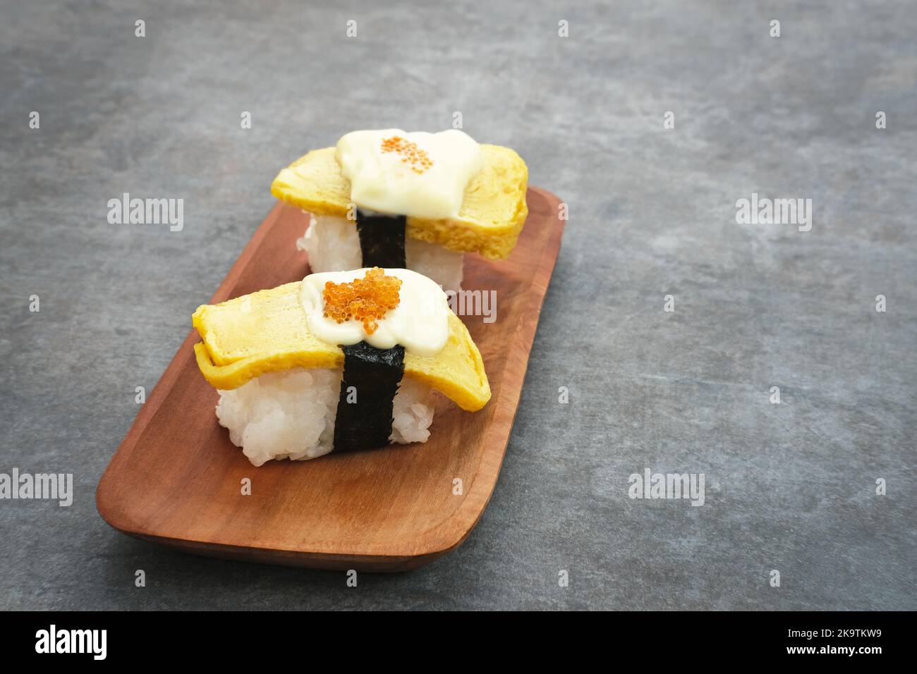 Petits pains de sushi aux œufs ou sushi au tamago avec caviar rouge, cuisine japonaise Banque D'Images