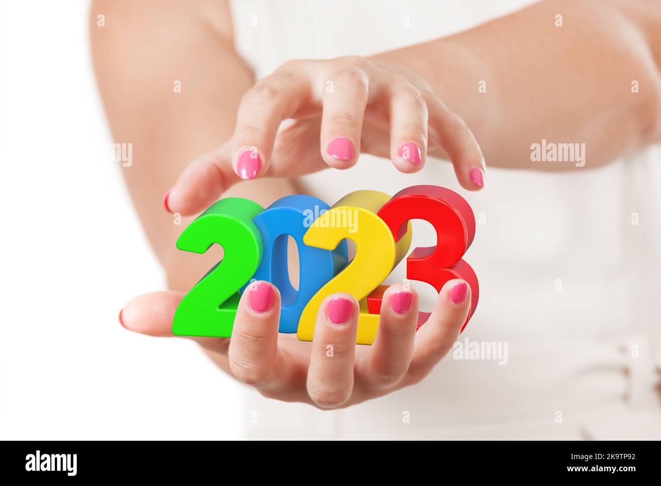 Deux mains de femme protégeant le nouvel an 2023 signe sur un fond blanc. Banque D'Images