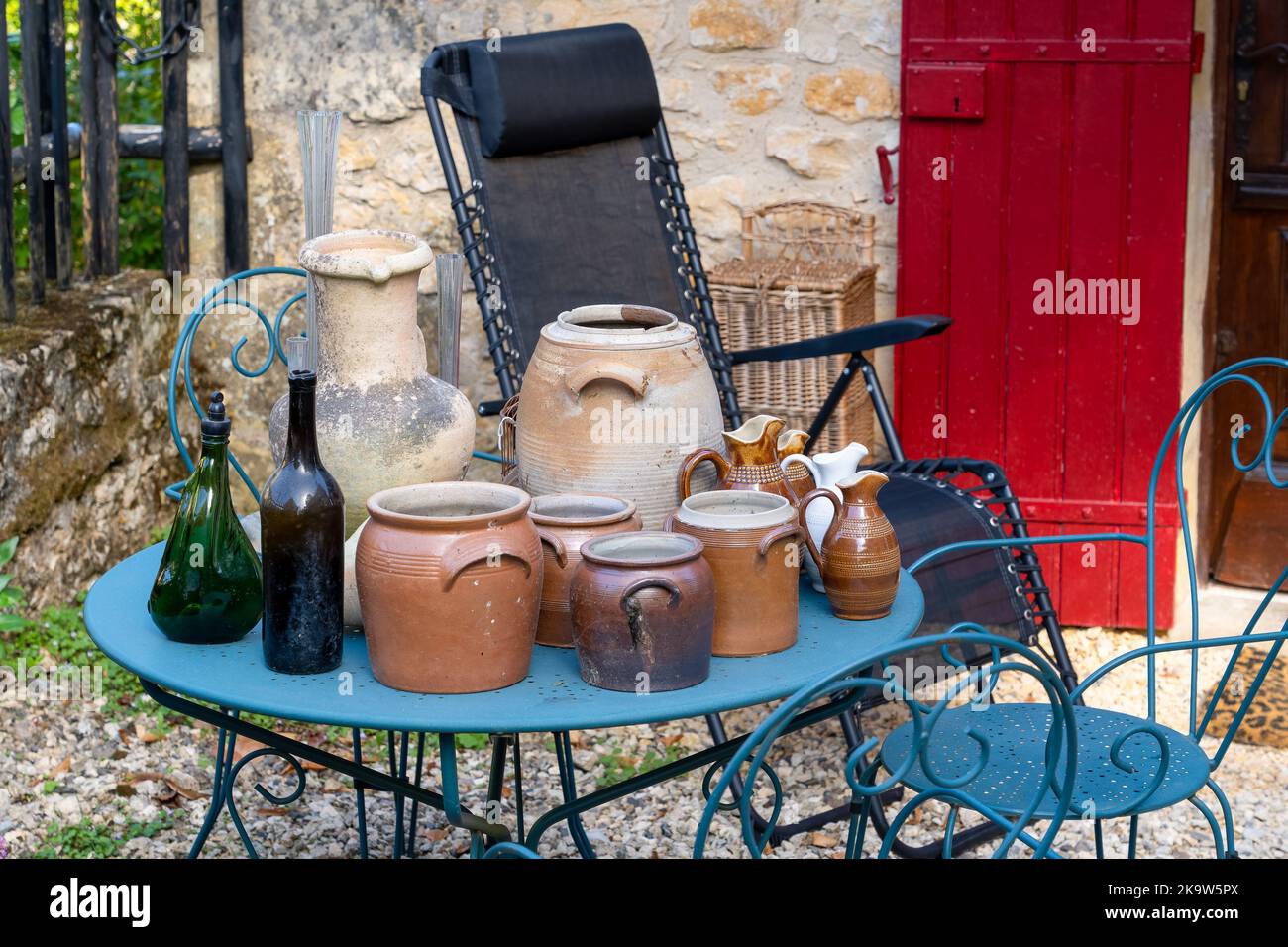 collection de pots et de bouteilles en faïence d'époque sur une table de jardin bleue Banque D'Images