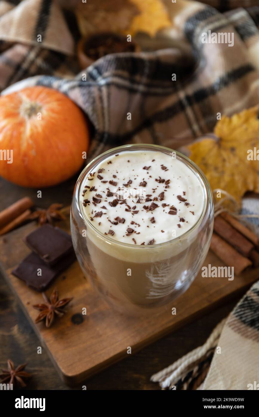 Concept d'automne saisonnier avec boisson. Verre de café latte macchiato, écharpe chaude et feuilles d'érable sur fond rustique. Banque D'Images
