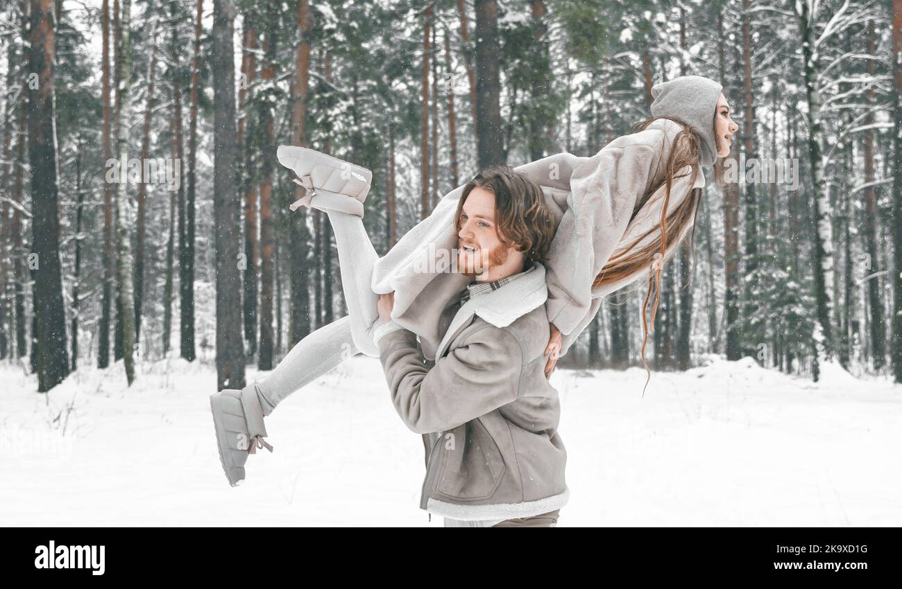 J'adore le romantique jeune couple. Guy tournant fille dans la forêt enneigée d'hiver avec des arbres. Marche, s'amuser, rire dans des vêtements élégants, fourrure manteau, veste, va Banque D'Images