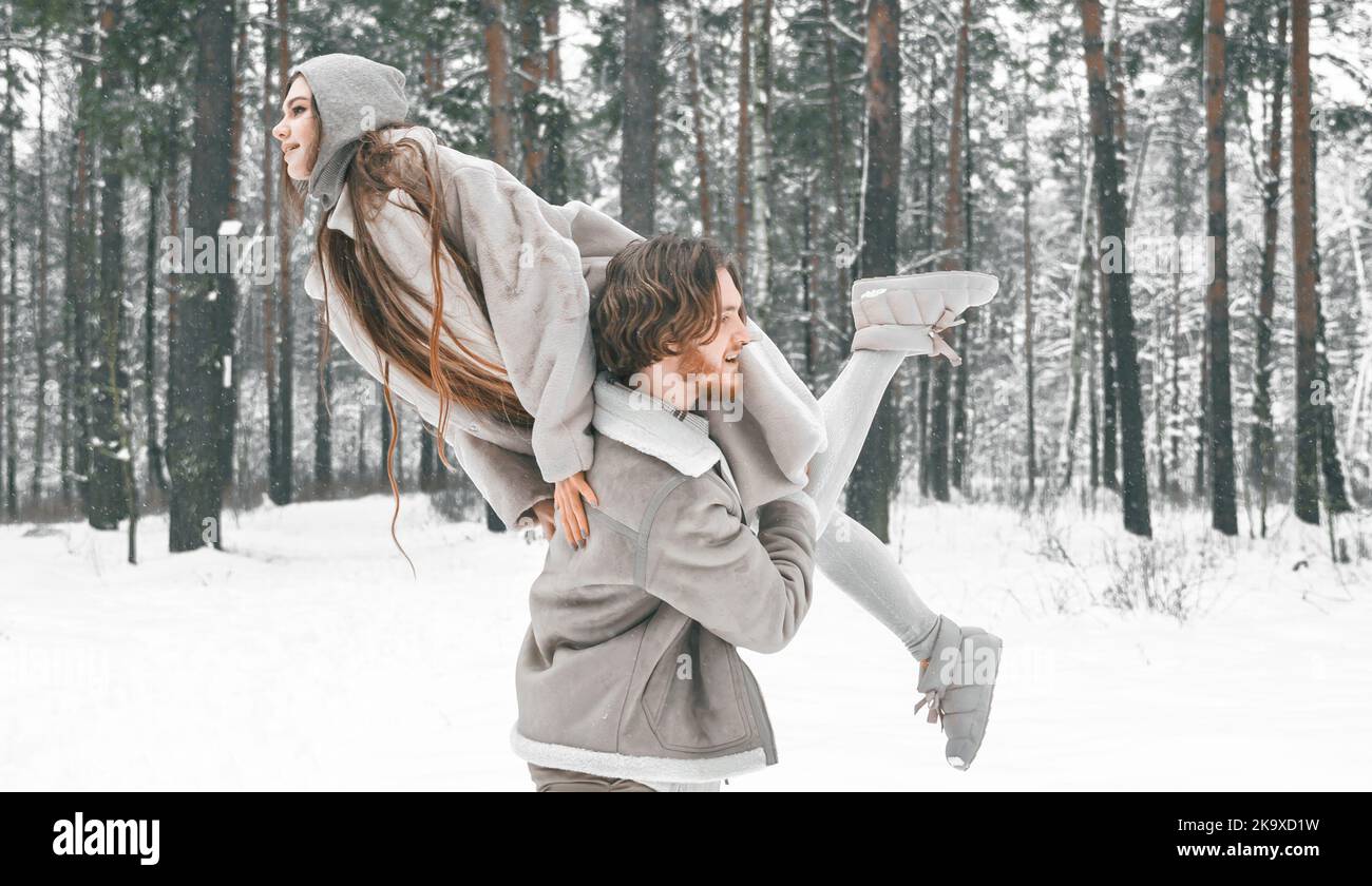 J'adore le romantique jeune couple. Guy tournant fille dans la forêt enneigée d'hiver avec des arbres. Marche, s'amuser, rire dans des vêtements élégants, fourrure manteau, veste, va Banque D'Images